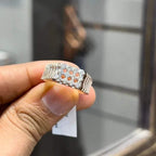 A man's hand displaying a cluster set diamonds ring made in gold.