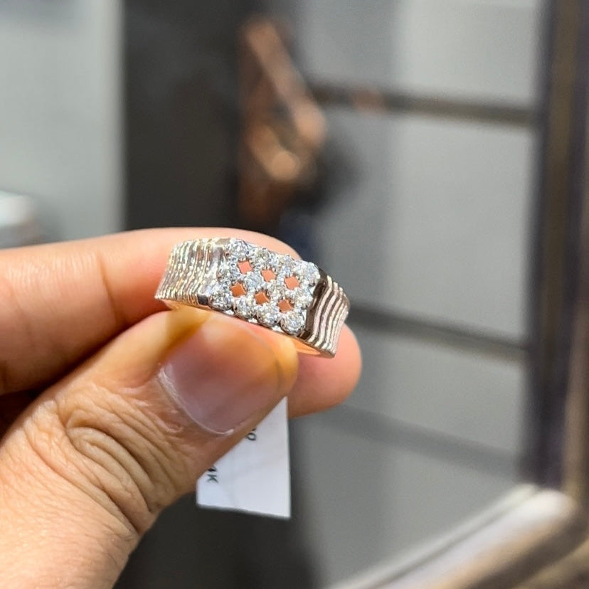 A man's hand displaying a cluster set diamonds ring made in gold.