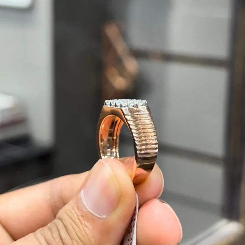 A man's hand displaying a cluster set diamonds ring made in gold.