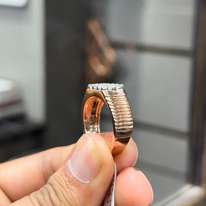 A man's hand displaying a cluster set diamonds ring made in gold.
