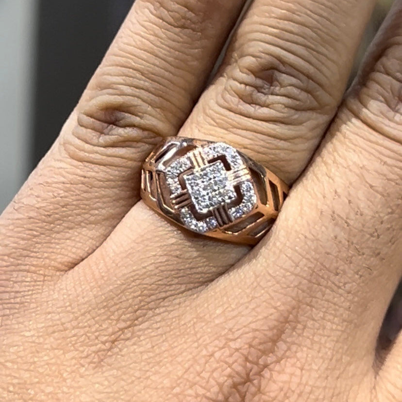 A man's hand displaying a gold band ring with diamonds cluster in the center.
