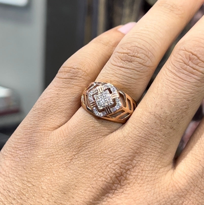 A man's hand displaying a gold band ring with diamonds cluster in the center.