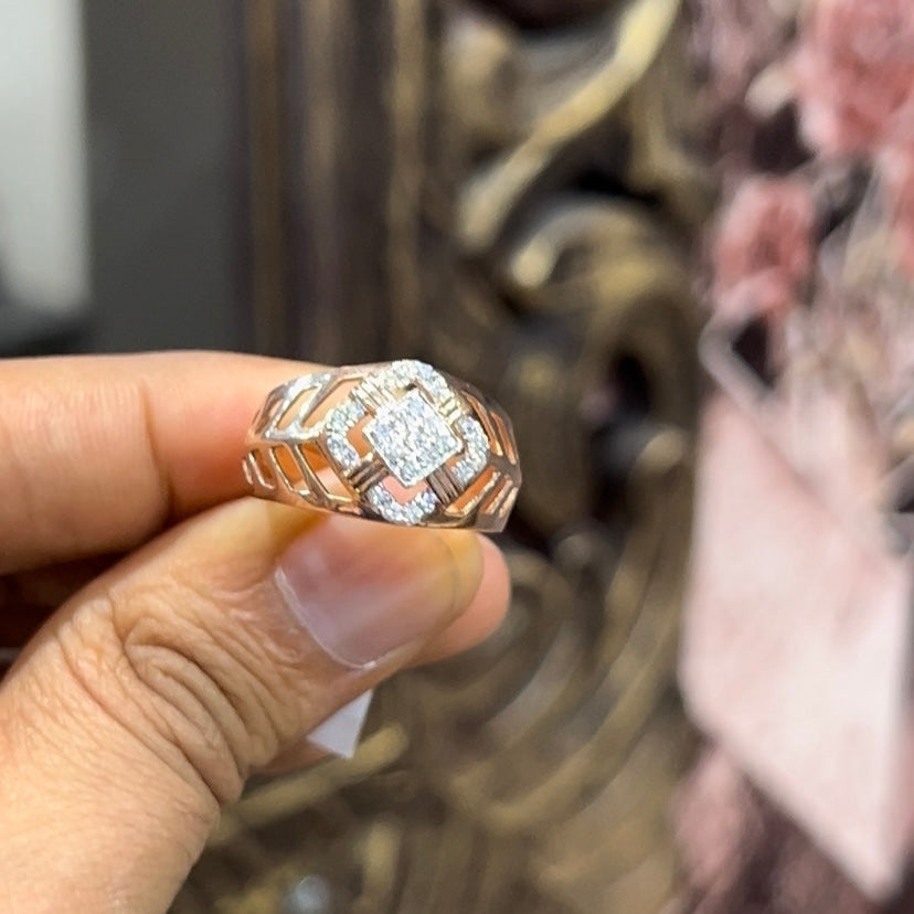 A man's hand displaying a gold band ring with diamonds cluster in the center.