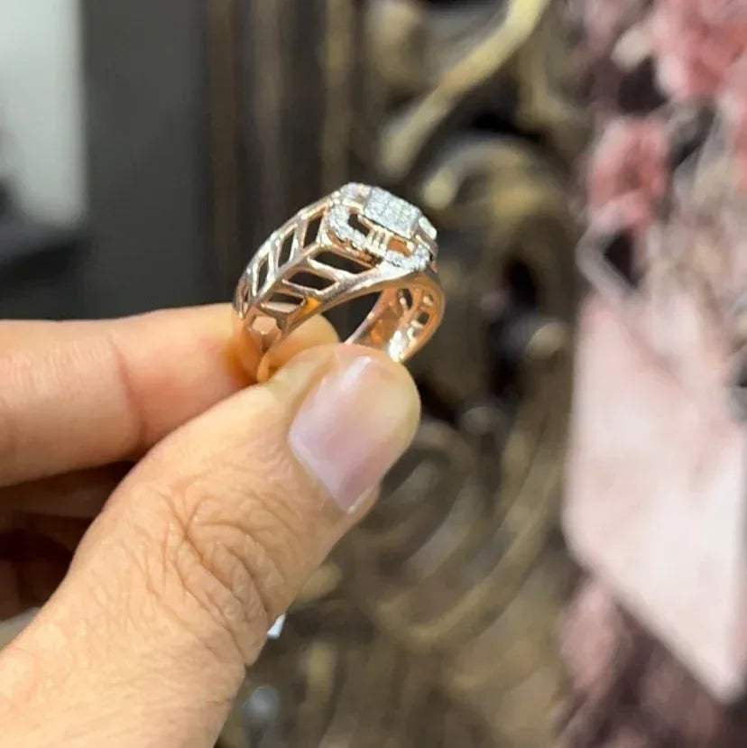 A man's hand displaying a gold band ring with diamonds cluster in the center.