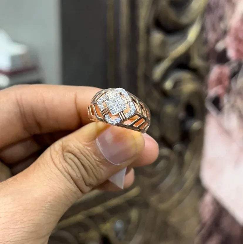 A man's hand displaying a gold band ring with diamonds cluster in the center.