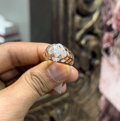 A man's hand displaying a gold band ring with diamonds cluster in the center.