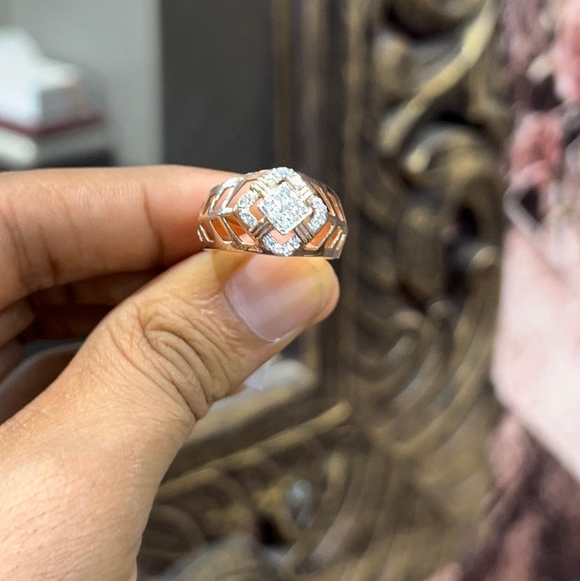 A man's hand displaying a gold band ring with diamonds cluster in the center.
