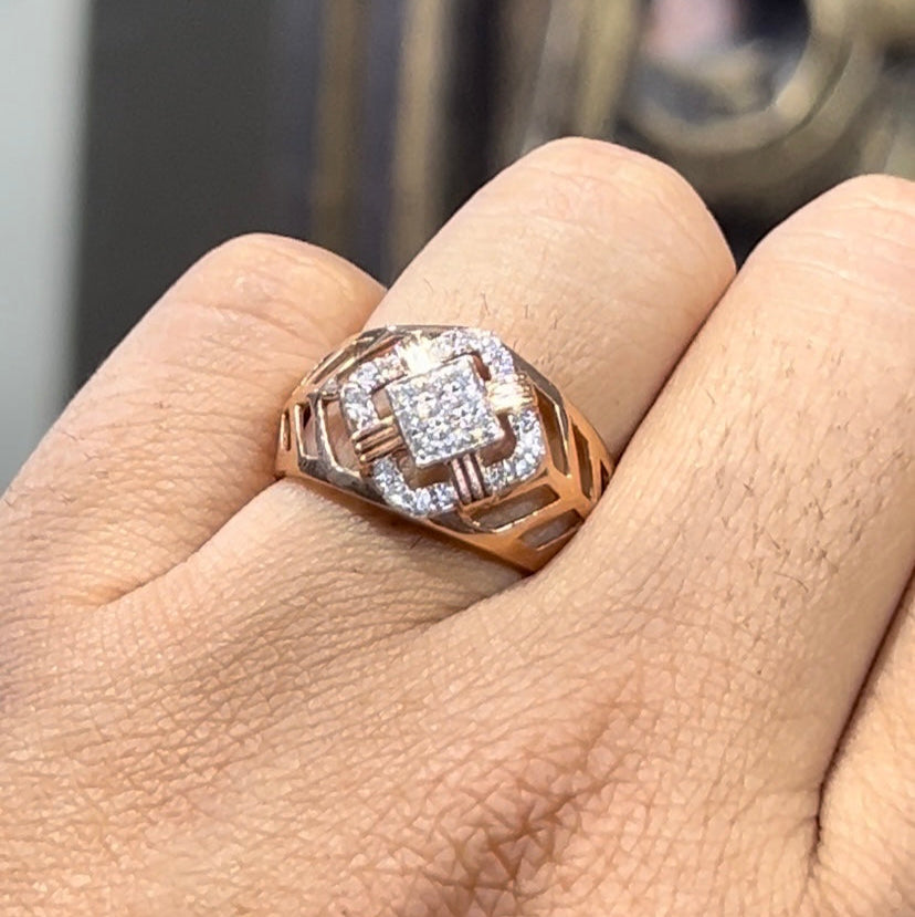 A man's hand displaying a gold band ring with diamonds cluster in the center.