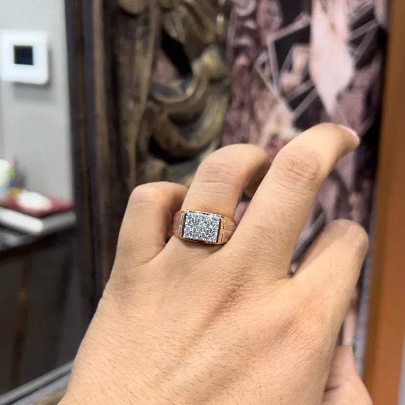 A man's hand displaying a diamond ring with a gold band.