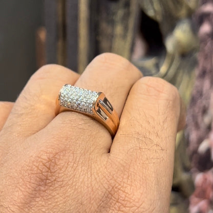 A man's hand holding a diamond men's ring with a gold band, featuring prominent diamonds centerpiece.