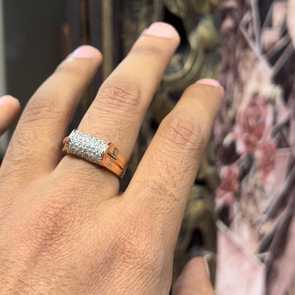 A man's hand holding a diamond men's ring with a gold band, featuring prominent diamonds centerpiece.