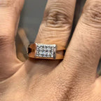 A man's hand displaying a diamond ring with a gold band.