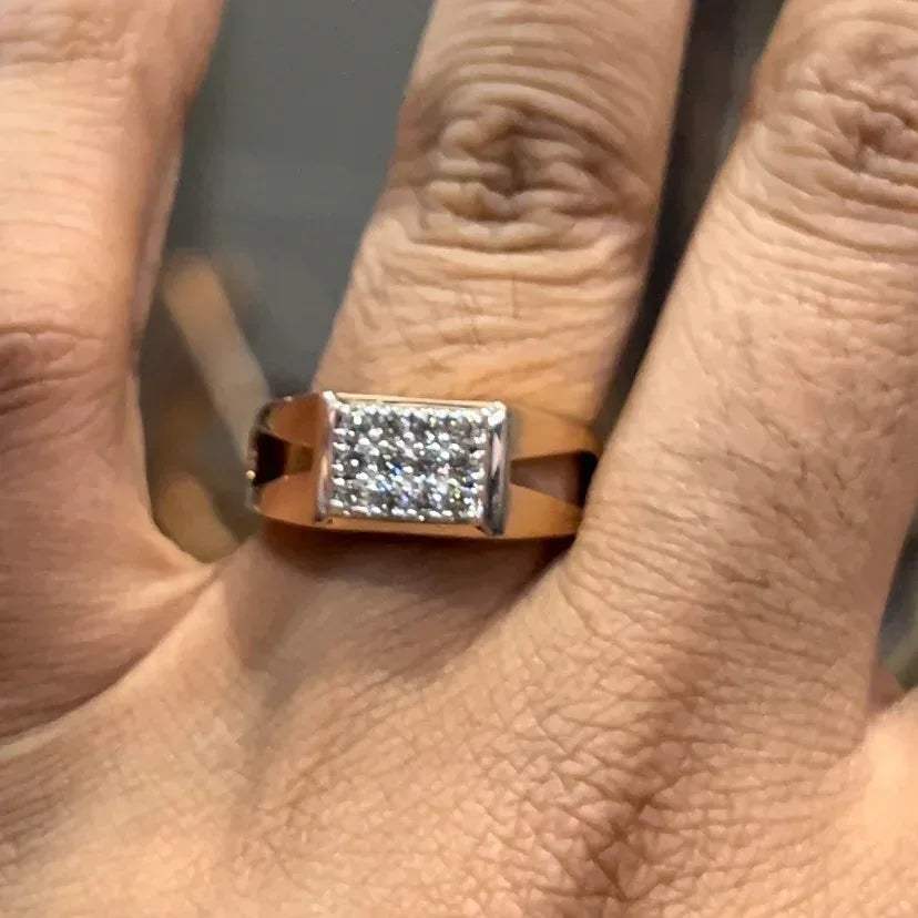A man's hand displaying a diamond ring with a gold band.