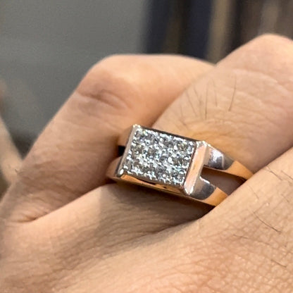 A man's hand displaying a diamond ring with a gold band.