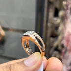 A man's hand displaying a diamond ring with a gold band.