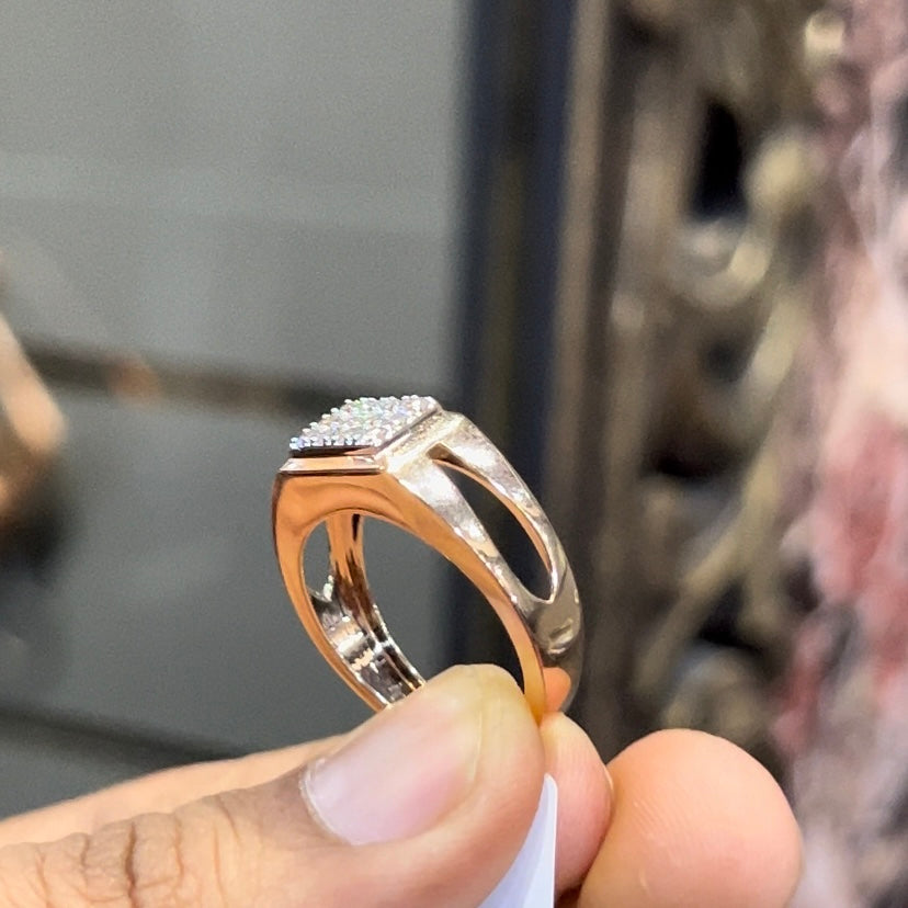 A man's hand displaying a diamond ring with a gold band.