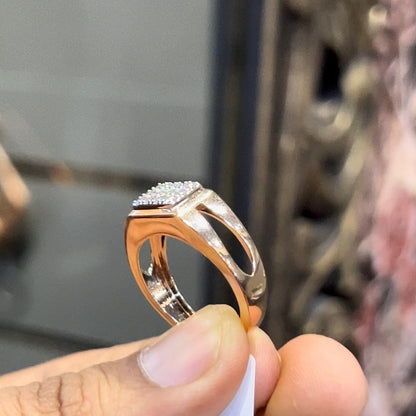 A man's hand displaying a diamond ring with a gold band.