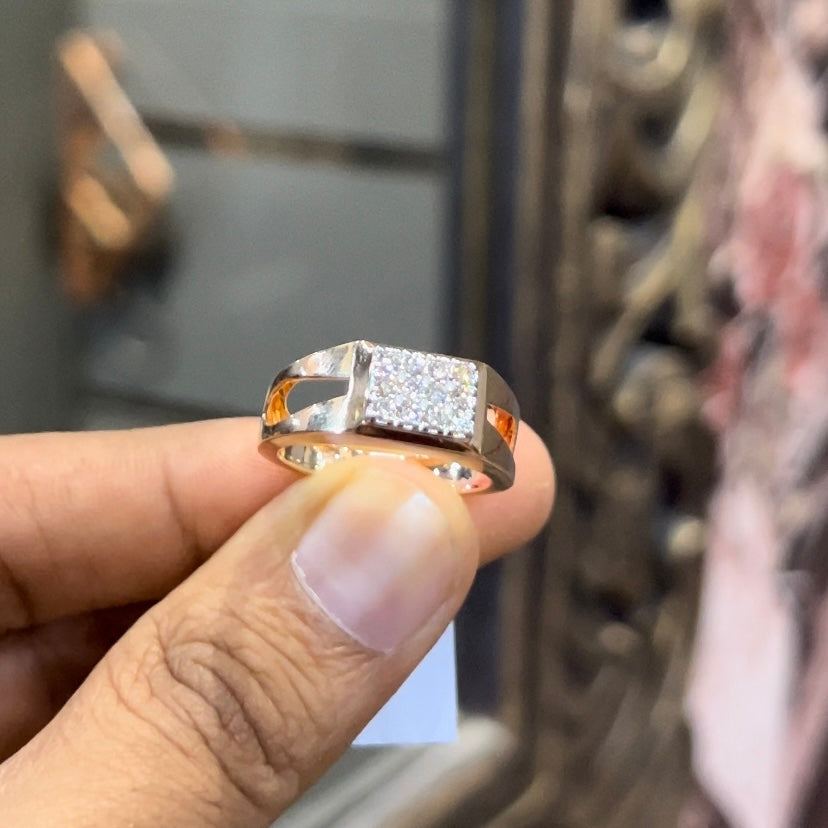 A man's hand displaying a diamond ring with a gold band.
