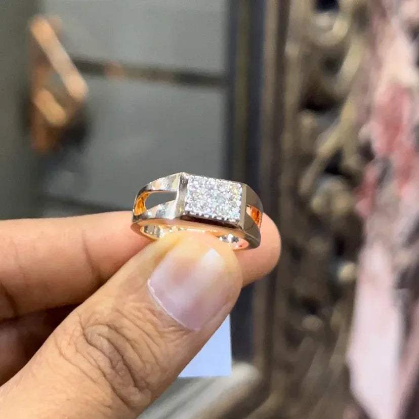 A man's hand displaying a diamond ring with a gold band.