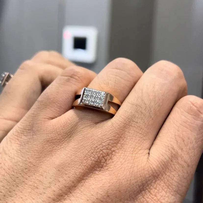 A man's hand displaying a diamond ring with a gold band.