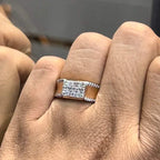 A man's hand displaying a gold band with a large diamond ring on his finger.