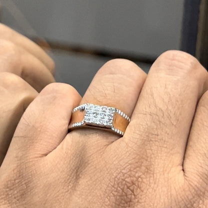A man's hand displaying a gold band with a large diamond ring on his finger.