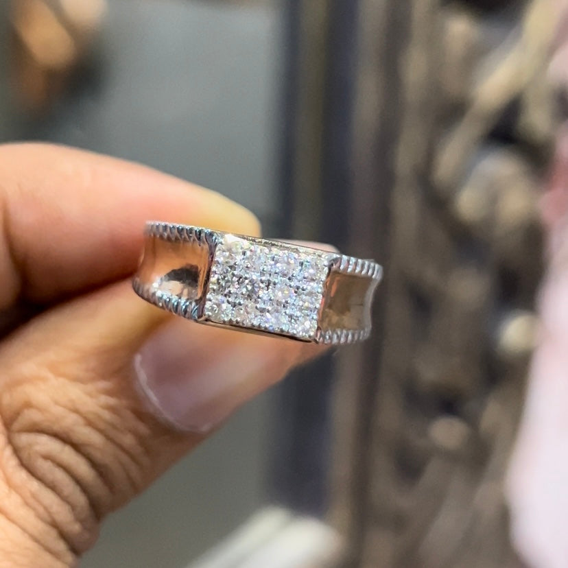 A man's hand displaying a gold band with a large diamond ring.
