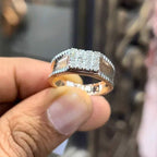 A man's hand displaying a gold band with a large diamond ring.