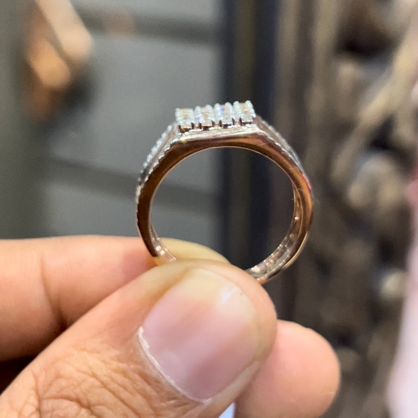 A man's hand displaying a gold band with a large diamond ring.