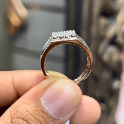 A man's hand displaying a gold band with a large diamond ring.