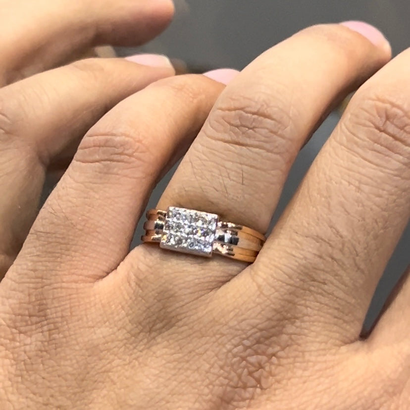 Men’s diamond ring in dual-tone gold with bold rectangular cluster of round diamonds at the center, flanked by sleek metal panels, shown worn on finger.