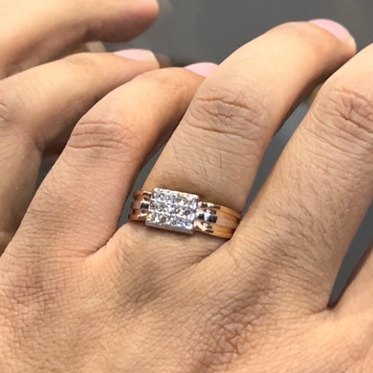 Men’s diamond ring in dual-tone gold with bold rectangular cluster of round diamonds at the center, flanked by sleek metal panels, shown worn on finger.
