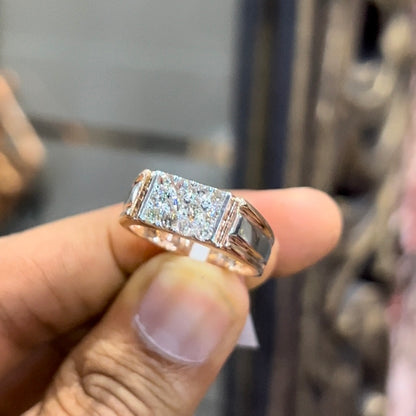 Men’s diamond ring in dual-tone gold with bold rectangular cluster of round diamonds at the center, flanked by sleek metal panels, shown by a person's hand.