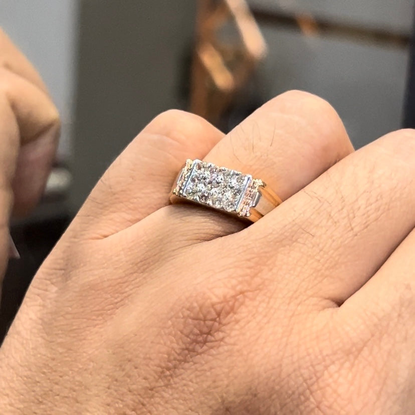 Men’s diamond ring in dual-tone gold with bold rectangular cluster of round diamonds at the center, flanked by sleek metal panels, shown worn on finger.
