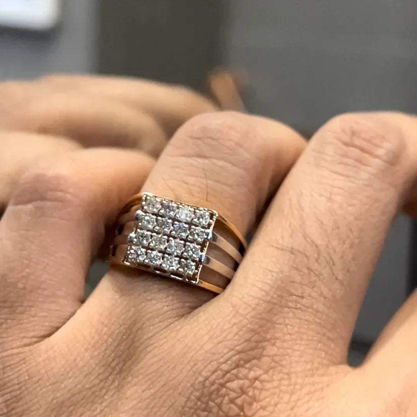 A man's hand holding a diamond ring with a solid gold band, featuring a clear diamond centerpiece.