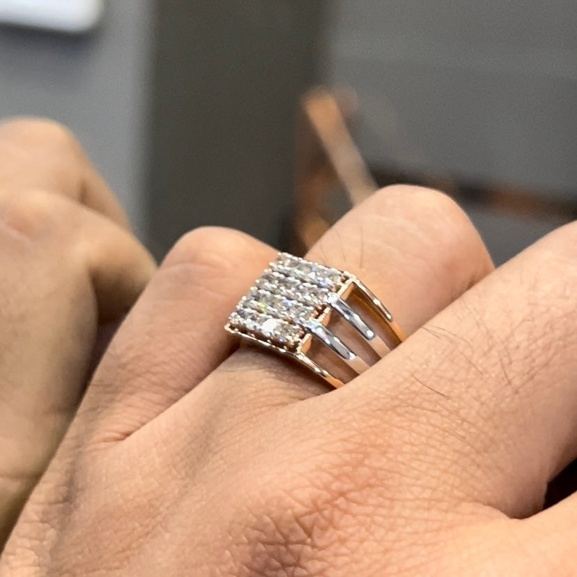 A man's hand holding a diamond ring with a solid gold band, featuring a clear diamond centerpiece.