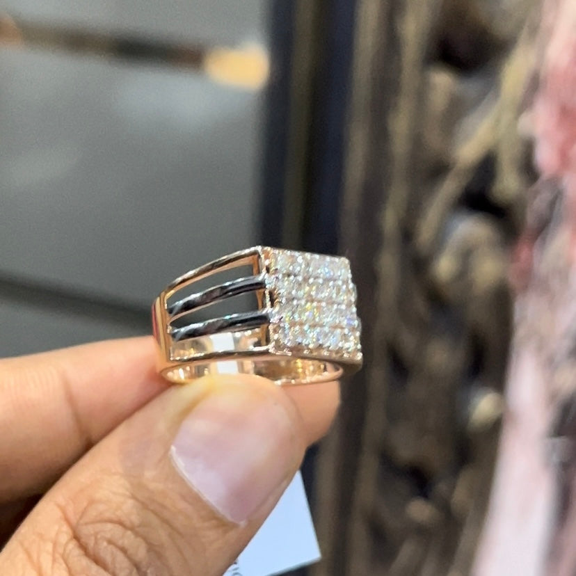 A man's hand holding a diamond ring with a solid gold band, featuring a clear diamond centerpiece.