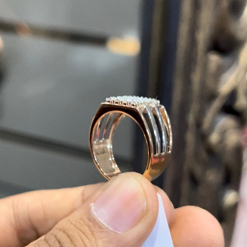 A man's hand holding a diamond ring with a solid gold band, featuring a clear diamond centerpiece.