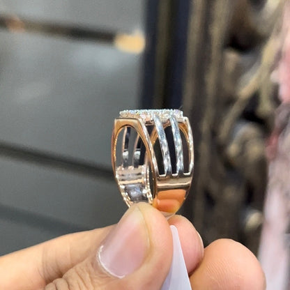 A man's hand holding a diamond ring with a solid gold band, featuring a clear diamond centerpiece.