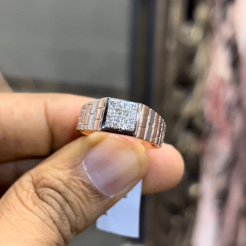 Stylish men’s diamond ring with a geometric square cluster centerpiece and textured rose gold band, shown in hand for scale.