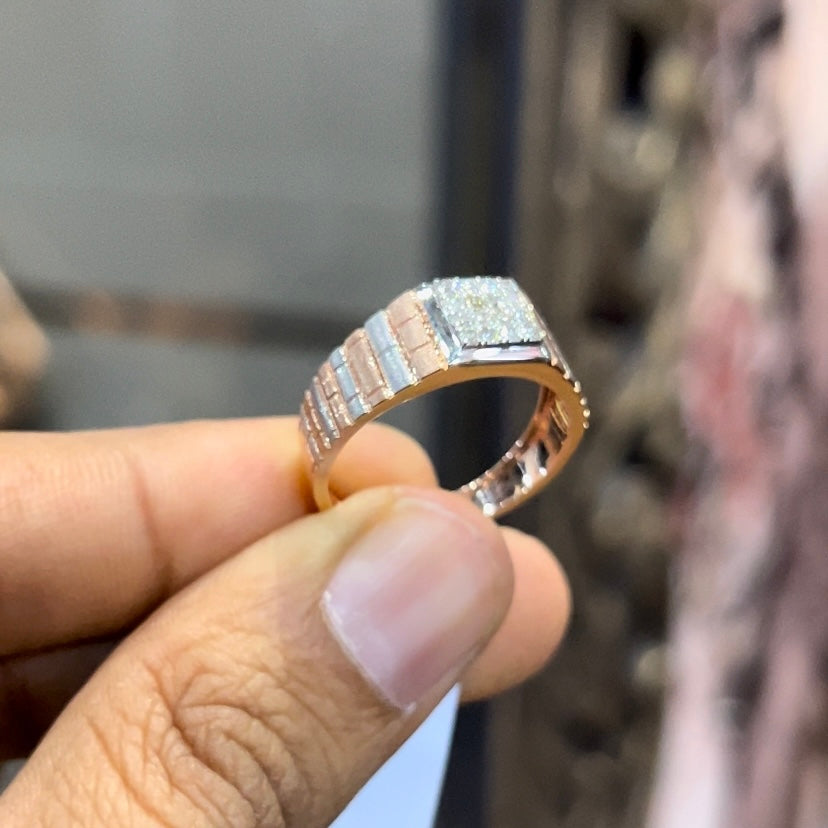 Stylish men’s diamond ring with a geometric square cluster centerpiece and textured rose gold band, shown in hand for scale.