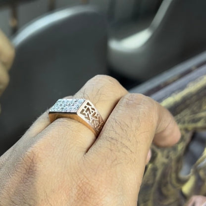 A man's hand displaying a diamond ring with a gold band. The ring has a polished finish with smaller diamonds.