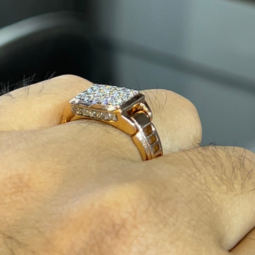 A man's hand holding a diamond ring with a solid gold band, featuring a prominent smaller diamonds along the band.