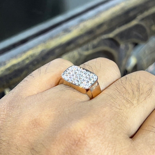 A man's hand holding a pave set diamond ring with a solid gold band, featuring a prominent smaller diamonds along the band.