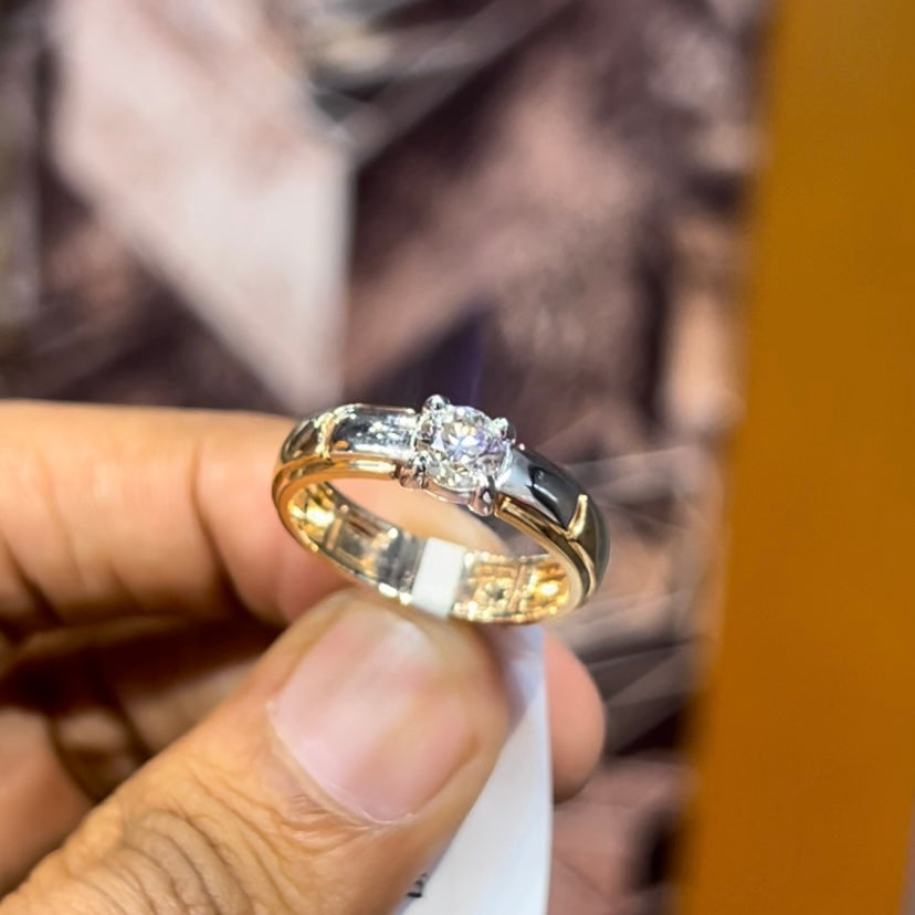 A man's hand holding a diamond solitaire ring with a gold ring.