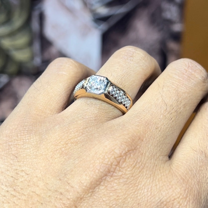 gold men's diamond ring with square solitaire and intricate lattice band detail shown on finger.