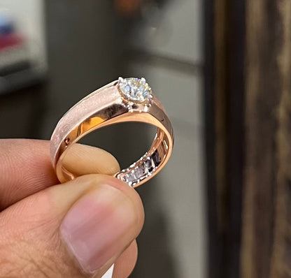 A man's hand displaying a gold band ring with a large, genuine diamond centerpiece.