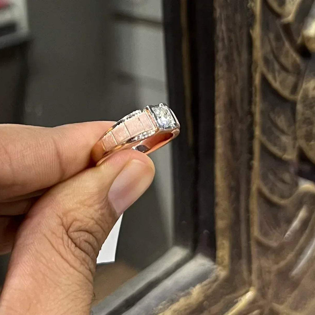 A man's hand displaying a gold band with a central genuine diamond solitaire ring.