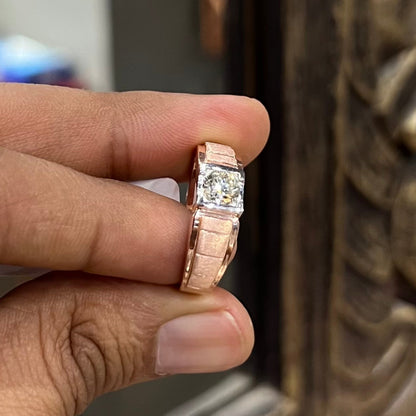 A man's hand displaying a gold band with a central genuine diamond solitaire ring.