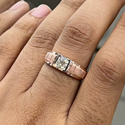 A man's hand displaying a gold band with a central genuine diamond solitaire ring.